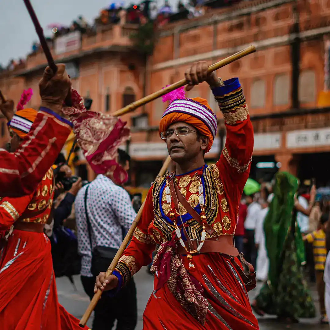 Rajasthani folk dancers in red costumes performing in a Jaipur street